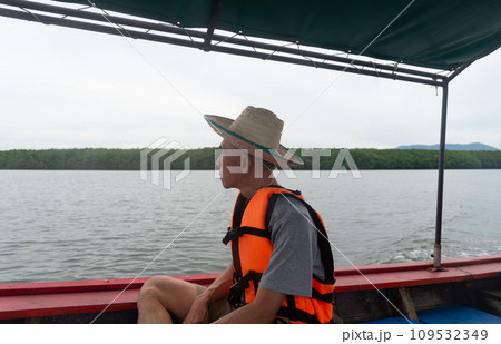 An adult Asian traveler sitting on long tail boat. Sustainability travel concept. 109532349