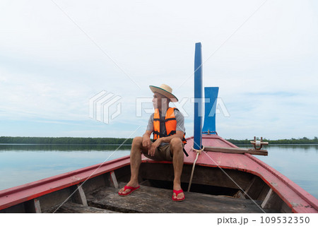 An adult Asian traveler sitting on long tail boat. Sustainability travel concept. 109532350