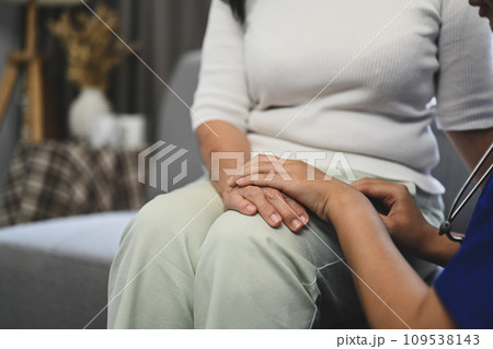 Cropped shot of doctor holding hands of senior patient for giving support, empathy and understanding. Cropped shot of doctor holding hands of senior patient for giving support, empathy and understanding. 109538143