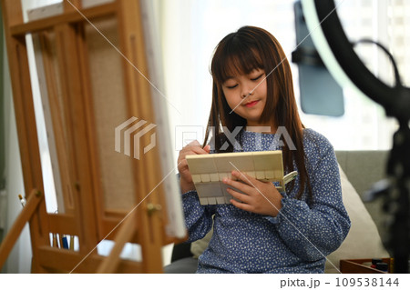 Cheerful asian girl painting picture at home and shooting video for social media. 109538144