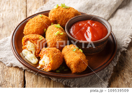 Italian Rice balls stuffed with mozzarella cheese and deep fried closeup on the plate. Horizontal 109539509