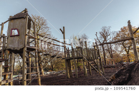 The Children's playground with Slide, Rope Net Bridge made of Wooden Tree trunk in acton park. The Children's playground with Slide, Rope Net Bridge made of Wooden Tree trunk in acton park. 109541760