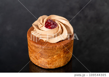 Cakes filled with cream and cherry jam. Box eclairs. New Year and holiday concept. 109544305