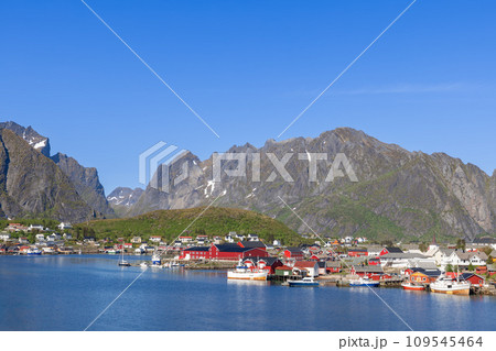 Panoramic Reine view: Red Rorbu house boats mountains, snow-caps, Lofoten Islands, Norway, sunny day 109545464