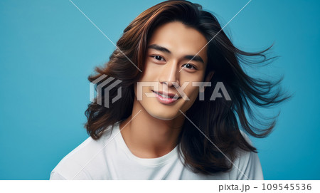 Elegant handsome smiling young Asian man with long hair on light blue, banner, copy space, portrait. 109545536