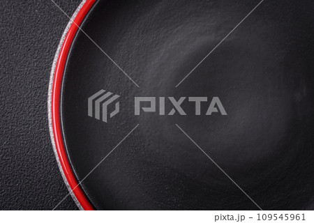 Bumpy empty ceramic plate on a textured concrete background 109545961
