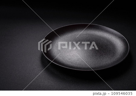 Bumpy empty ceramic plate on a textured concrete background Bumpy empty ceramic plate on a textured concrete background 109546035