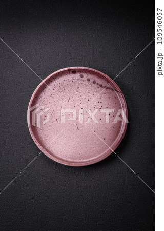 Bumpy empty ceramic plate on a textured concrete background 109546057