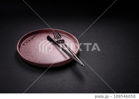Bumpy empty ceramic plate on a textured concrete background 109546058