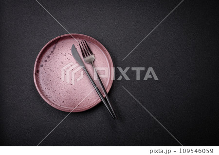 Bumpy empty ceramic plate on a textured concrete background 109546059