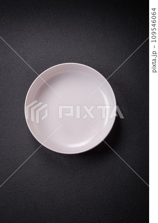 Bumpy empty ceramic plate on a textured concrete background Bumpy empty ceramic plate on a textured concrete background 109546064
