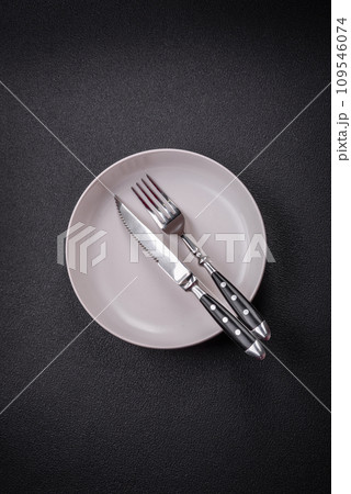 Bumpy empty ceramic plate on a textured concrete background Bumpy empty ceramic plate on a textured concrete background 109546074