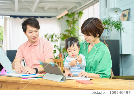 赤ちゃんを抱えてパソコン操作をする女性と男性 109546497