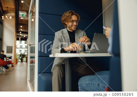 Two diverse business colleagues working together on project sitting in modern meeting room Two diverse business colleagues working together on project sitting in modern meeting room 109550265