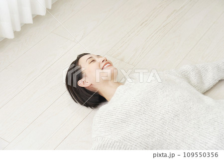 フローリングに仰向けで寝転ぶ中年女性 109550356