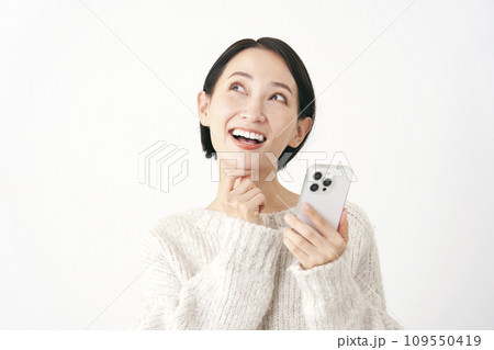 スマホを持って想像する中年女性 白背景 スマホを持って想像する中年女性 白背景 109550419