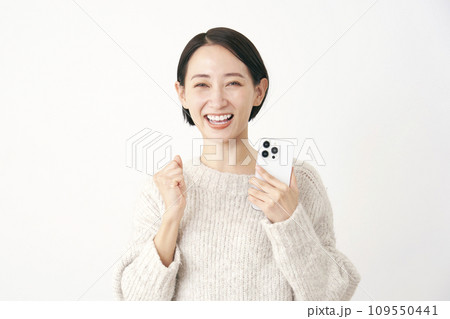 スマホを持ってガッツポーズをする中年女性　白背景 109550441