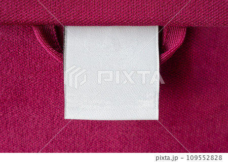 Blank white laundry care clothes label on red fabric texture background 109552828