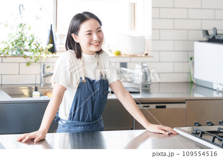 キッチンで料理する笑顔の女性 109554516
