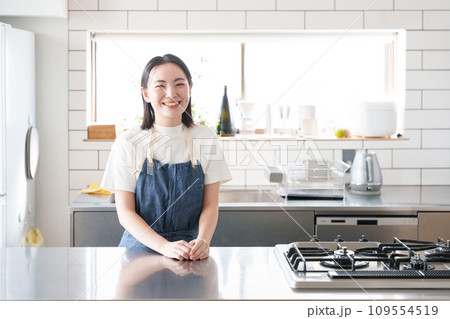 キッチンで料理する笑顔の女性 109554519