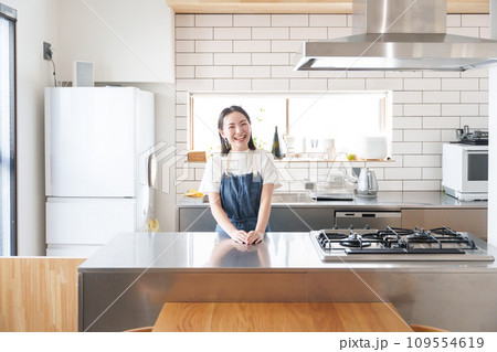 キッチンで料理する笑顔の女性 キッチンで料理する笑顔の女性 109554619