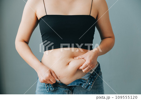 fat woman, fat belly, chubby, obese woman hand holding excessive belly fat with measure tape, woman diet lifestyle concept 109555120