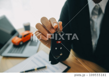 Salesman send key to customer after good deal agreement, successful car loan contract buying or selling new vehicle. Salesman send key to customer after good deal agreement, successful car loan contract buying or selling new vehicle. 109555181