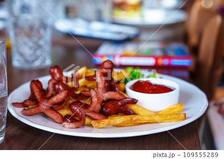Delicious Children's Menu with Sausages, French Fries, and Ketchup in a Restaurant Delicious Children's Menu with Sausages, French Fries, and Ketchup in a Restaurant 109555289