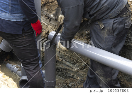 住宅の排水を下水道につなげる配管工事する人物 住宅の排水を下水道につなげる配管工事する人物 109557808