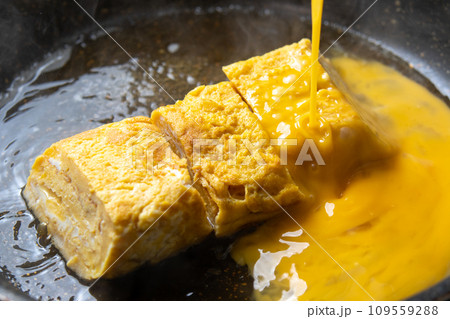 卵焼きの卵とじ、調理シーン。だし汁で煮た卵焼きに溶き卵を加える。 109559288