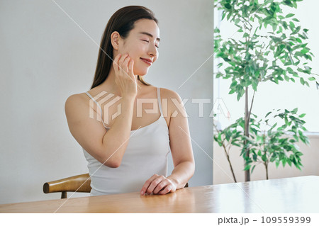 顔をマッサージして肌のお手入れをする30代女性 顔をマッサージして肌のお手入れをする30代女性 109559399