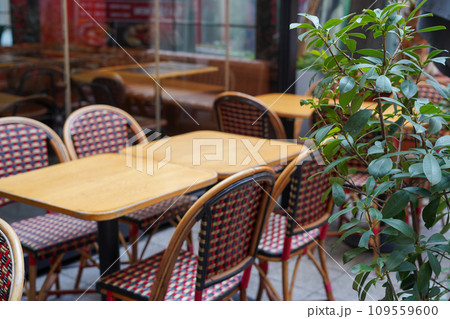 Outdoor empty restaurant terrace with wooden tables, chairs and green plant Outdoor empty restaurant terrace with wooden tables, chairs and green plant 109559600