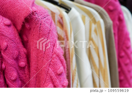 Stylish warm colorful clothes on hangers in the store 109559619