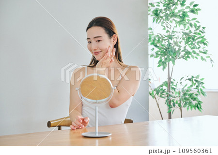 顔をマッサージして肌のお手入れをする30代女性 顔をマッサージして肌のお手入れをする30代女性 109560361