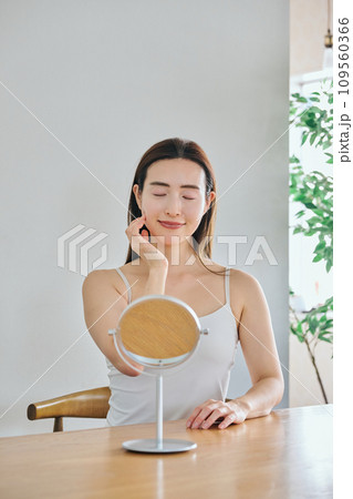 顔をマッサージして肌のお手入れをする30代女性 顔をマッサージして肌のお手入れをする30代女性 109560366