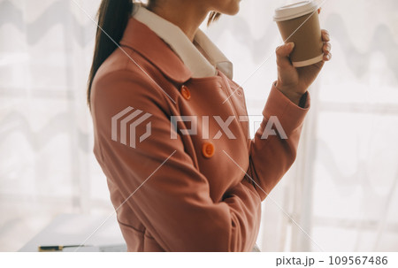 Attractive smiling young asian business woman work at home office, Asian woman working on laptop computer holding tablet. 109567486