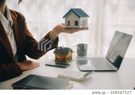 Real estate broker agent presenting and consult to customer to decision making sign insurance form agreement, buy and sell home model, concerning mortgage loan offer for and house insurance 109567527