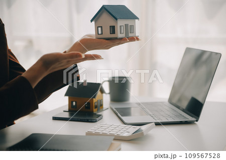 Real estate broker agent presenting and consult to customer to decision making sign insurance form agreement, buy and sell home model, concerning mortgage loan offer for and house insurance Real estate broker agent presenting and consult to customer to decision making sign insurance form agreement, buy and sell home model, concerning mortgage loan offer for and house insurance 109567528