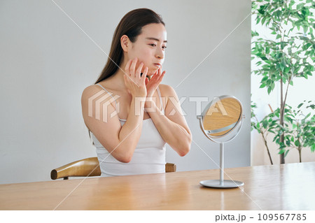 口元筋トレでほうれい線伸ばしのストレッチをする30代女性 109567785