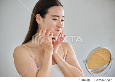 口元筋トレでほうれい線伸ばしのストレッチをする30代女性 口元筋トレでほうれい線伸ばしのストレッチをする30代女性 109567787