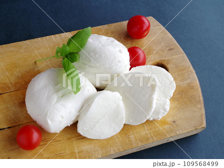 木製プレートにモッツァレラチーズ 赤いトマト グリーンのバジル 黒の背景 木製プレートにモッツァレラチーズ 赤いトマト グリーンのバジル 黒の背景 109568499