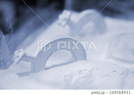 Objects printed on a 3D printer from powdered polyamide lying in white polyamide powder. Models printed on a 3D printer from powdered plastic close-up. MJF Multi Jet Fusion. 3D printing technology 109569431