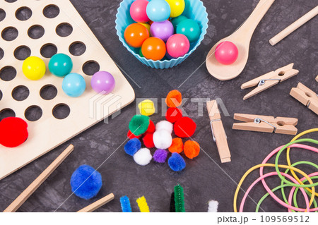 Colorful pompoms, balls and rubber erasers using for development of kids motor skills Colorful pompoms, balls and rubber erasers using for development of kids motor skills 109569512
