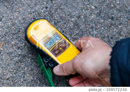 Male hand holding a dosimeter. Measurement of radiation levels by the Geiger counter in Chernobyl Exclusion Zone, Ukraine Male hand holding a dosimeter. Measurement of radiation levels by the Geiger counter in Chernobyl Exclusion Zone, Ukraine 109572230
