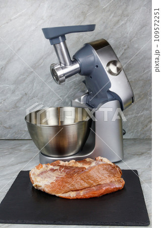 Electric eat grinder and fresh meat on kitchen table. Preparation of minced meat 109572251