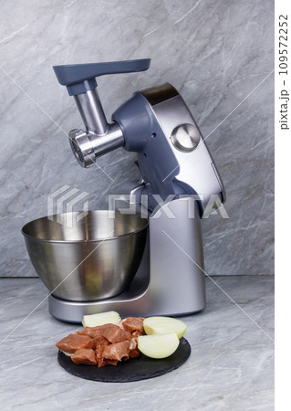 Electric eat grinder and fresh meat on kitchen table. Preparation of minced meat 109572252