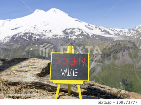 Property value symbol. Concept words Property value on beautiful black chalk blackboard. Beautiful mountain Elbrus blue sky background. Business property value concept. Copy space. 109573777