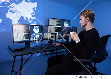 Back View in the Cyber Security Control Center Operator Working. Multiple Screens Showing Technical Data and Alerts. 109574950
