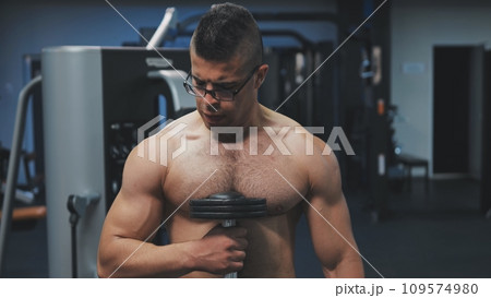 Muscular arab man training with dumbbells in the gym. Muscular arab man training with dumbbells in the gym. 109574980
