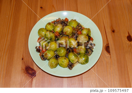 Brussels sprouts roasted with mushrooms and carrot on wooden table 109575497